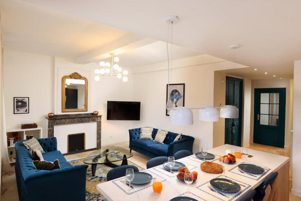Una sala de estar con una mesa y sillas azules. en L'art de Gambetta ConciergerieDameCarcas, en Carcassonne