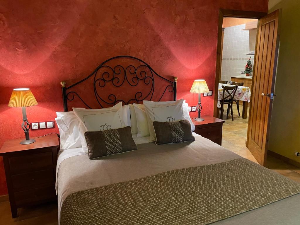 a bedroom with a large bed with red walls at La Casassa de Ribes in Ribes de Freser
