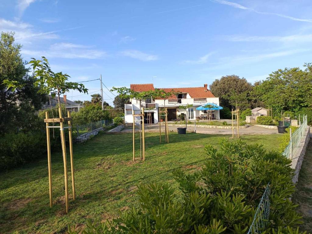 a yard with a group of poles in the grass at Apartment Martina in Rab