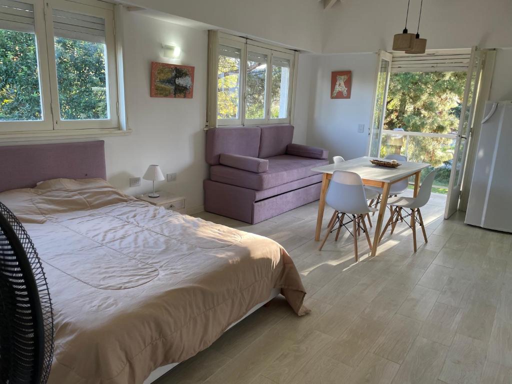 Un dormitorio con una cama, una mesa y una silla. en El IDEAL, en Pinamar