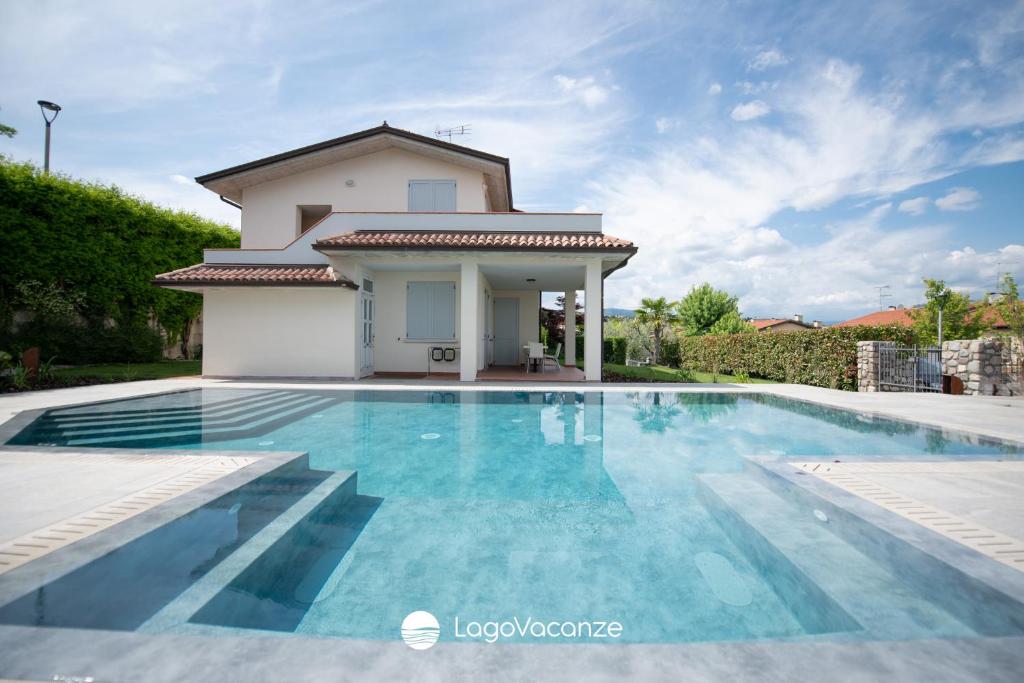 a swimming pool in front of a villa at Exclusive Villa le Palme in Polpenazze del Garda