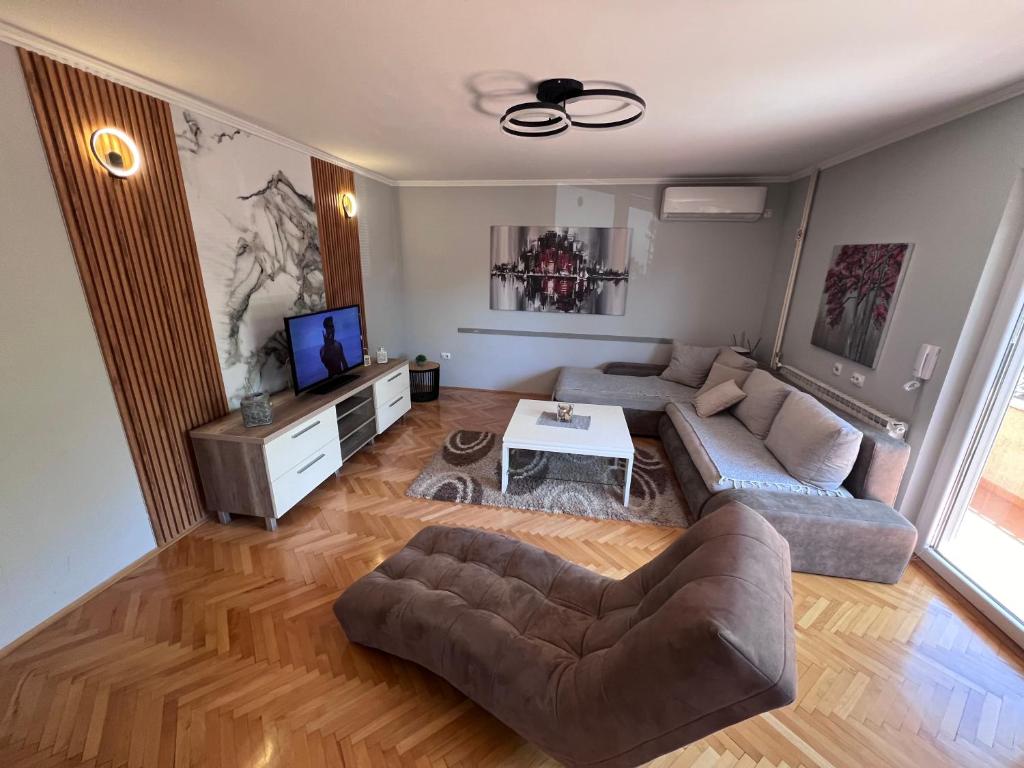 Apartment Ortakovski في إسكوبية: غرفة معيشة مع أريكة وطاولة
