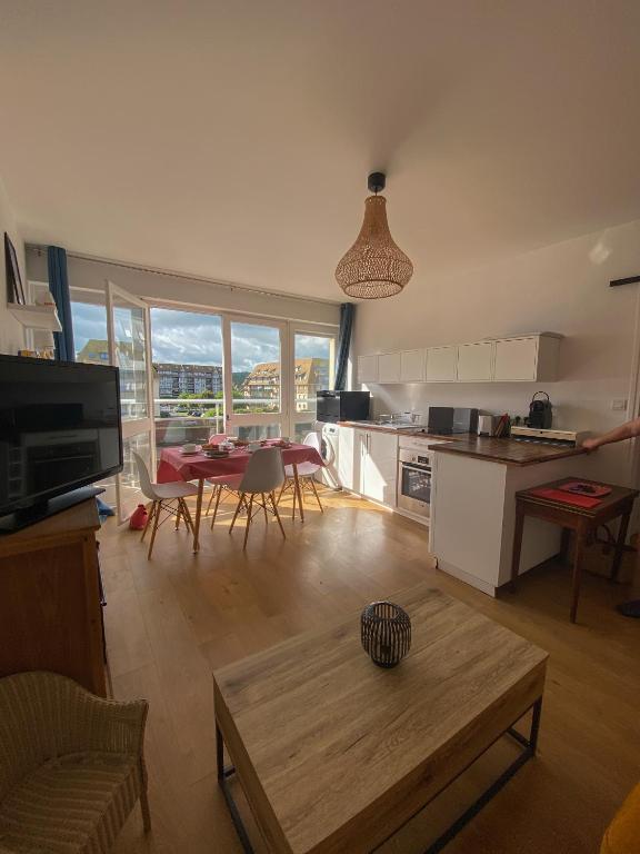 salon ze stołem i kuchnią z widokiem w obiekcie Le petit Villers w mieście Villers-sur-Mer