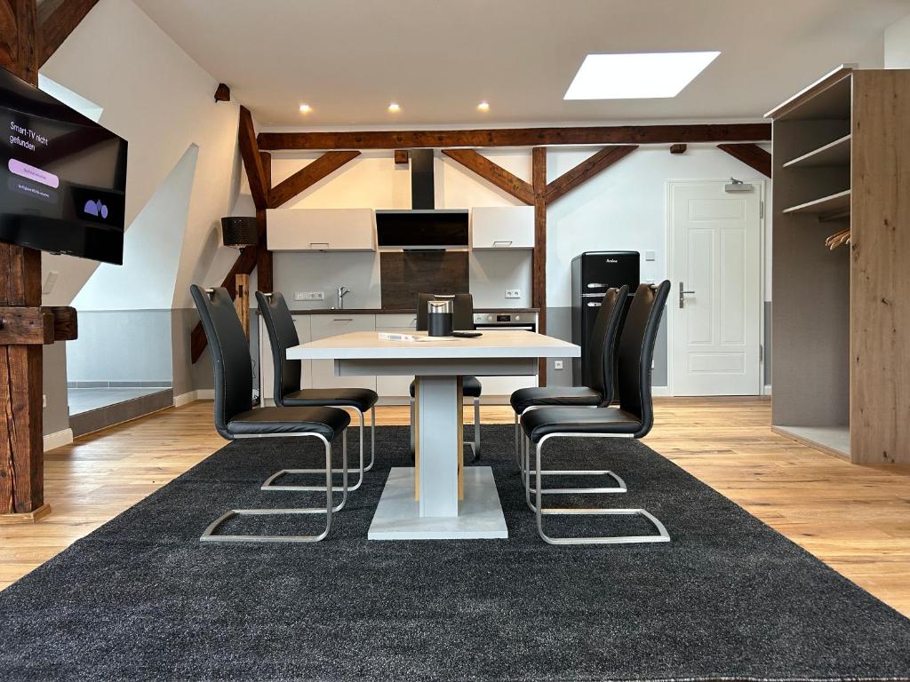 uma sala de jantar com uma mesa branca e cadeiras pretas em Moseltürmchen Cochem em Cochem