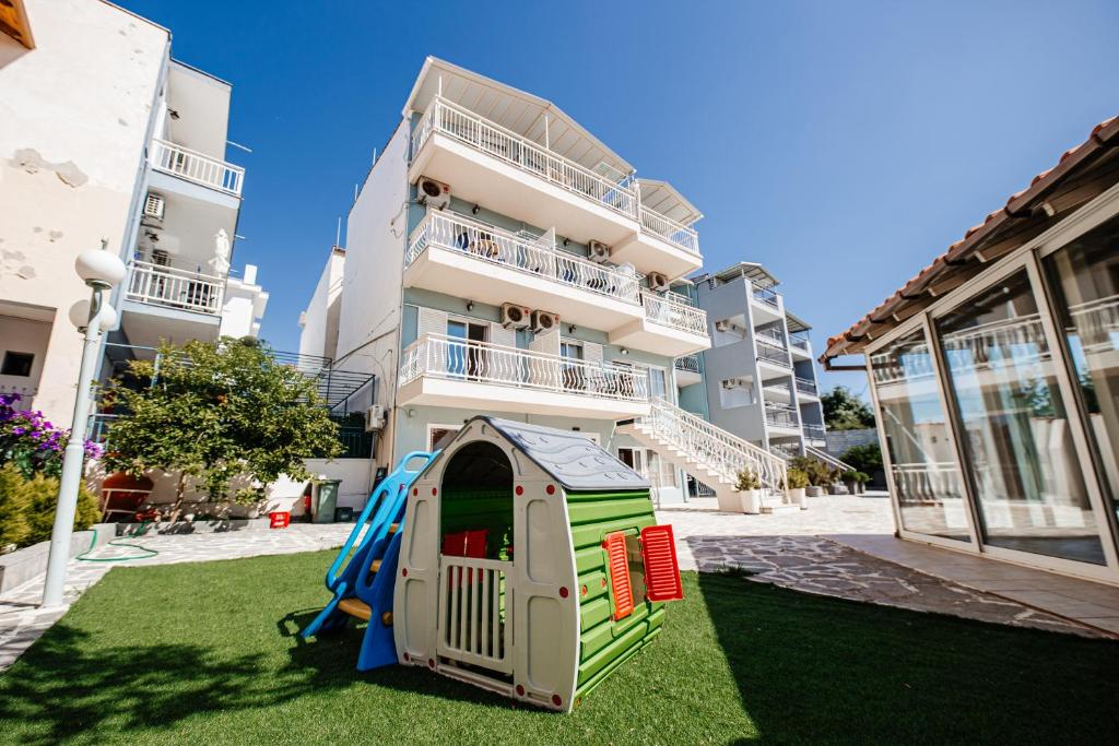 un parque infantil en un patio frente a un edificio en Hotel Marialena en Potos
