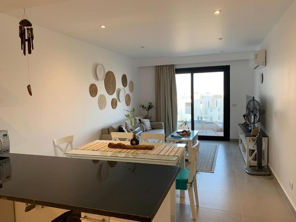 eine Küche und ein Wohnzimmer mit einem Tisch und einer Couch in der Unterkunft Caesar Bay Resort Ras Al Hekma in Dawwār Abū Duray‘ah ‘Abd al Karīm