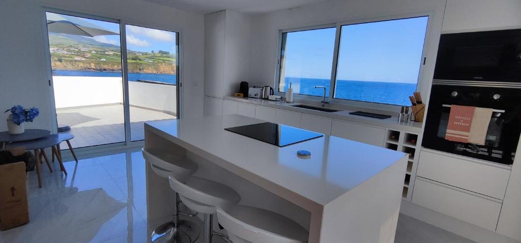 a white kitchen with a view of the ocean at Furna Blue View in Lagoa