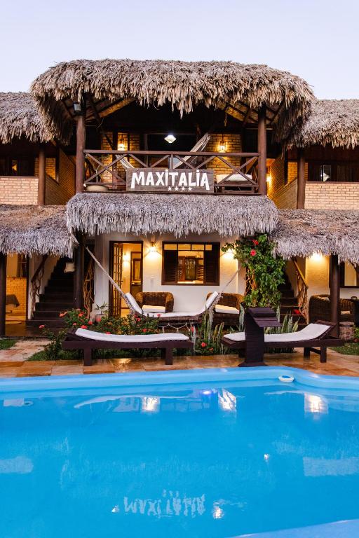 a resort with a swimming pool in front of it at Pousada Maxitalia in Jericoacoara
