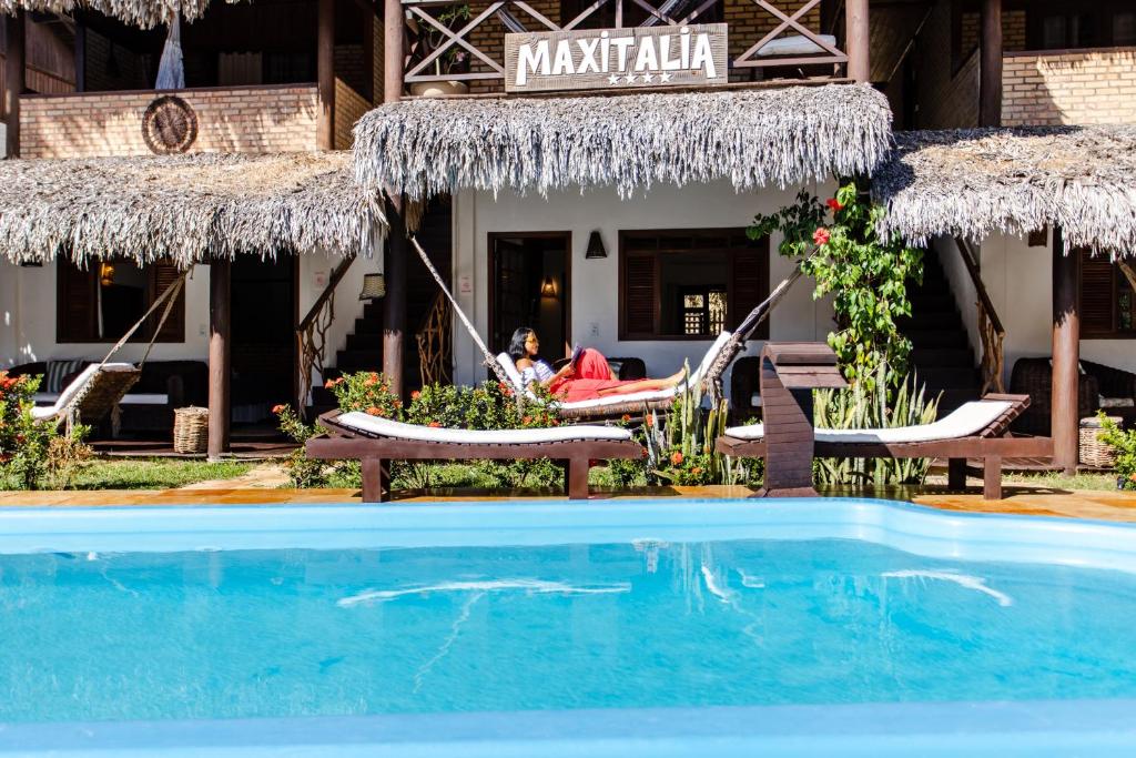 un complejo con piscina frente a un restaurante en Villa Samambaia na Pousada Maxitalia, en Jericoacoara