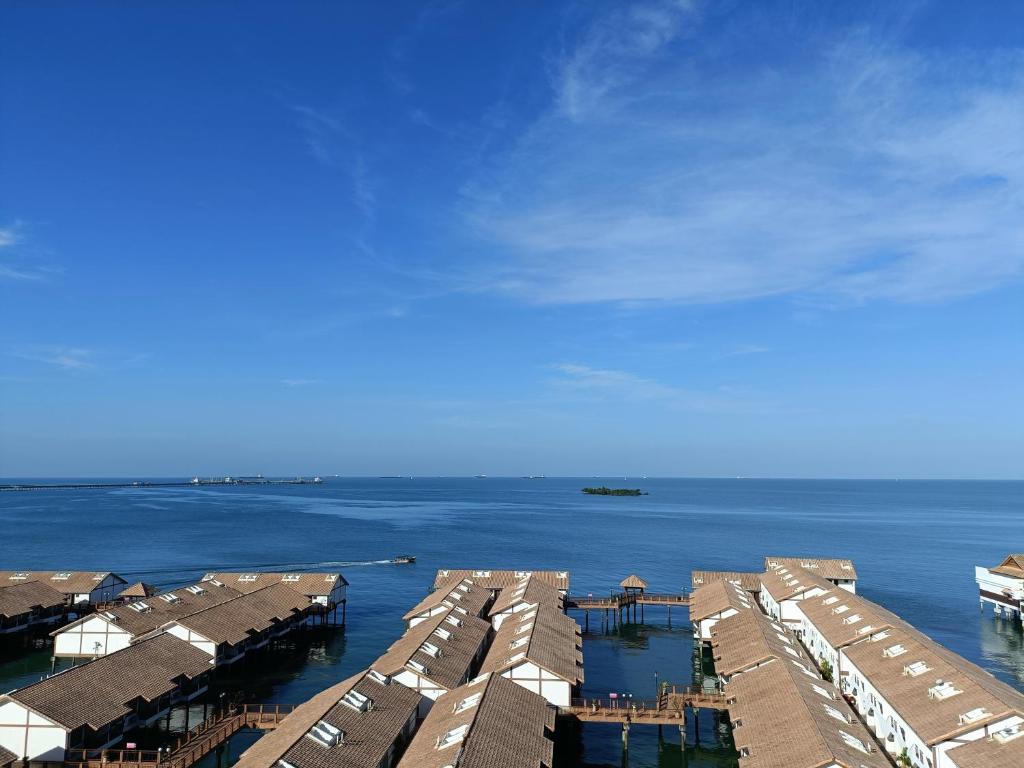 a group of houses in the water with a sky at PD Seaview Sunset Premium Tower Private Suite in Port Dickson