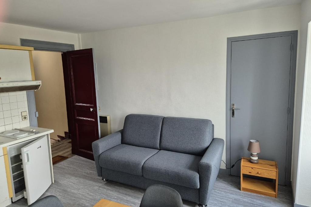 un salon avec un canapé gris et une table dans l'établissement Apartment in the heart of Trouville-sur-Mer, à Trouville-sur-Mer