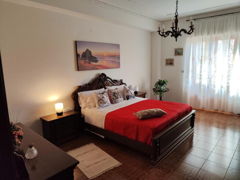 una camera con un letto con una coperta rossa di Panoramico WiFi TV Centro Storico a Casteldaccia