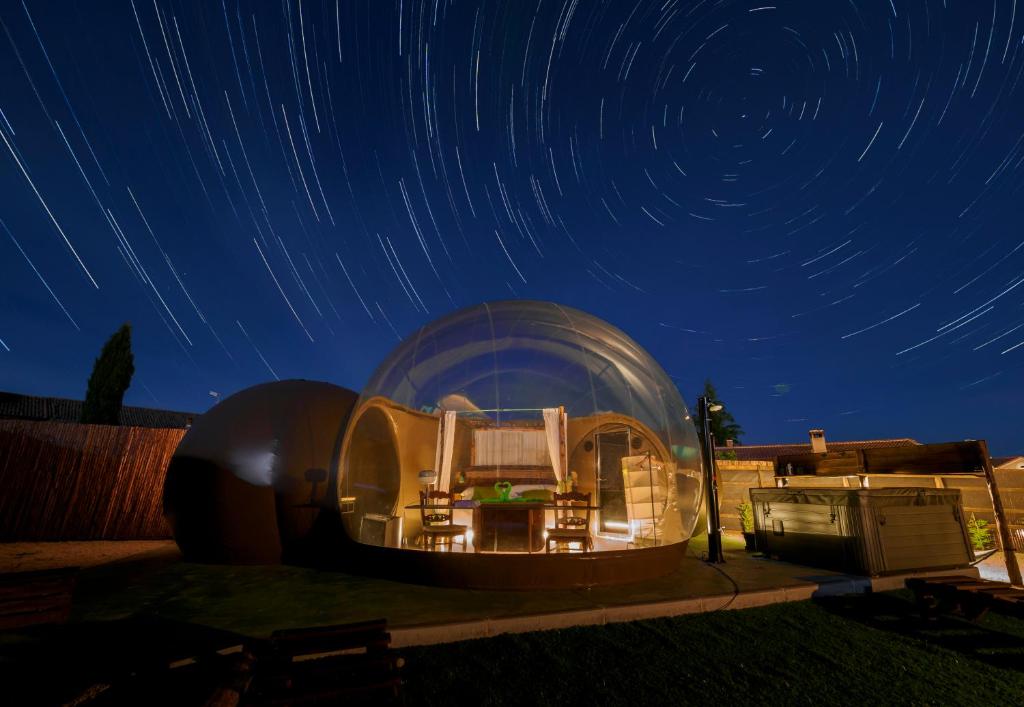una gran casa en la cúpula con una habitación en ella por la noche en COSMOVEROS, Bubble Experience, en Pedraza-Segovia