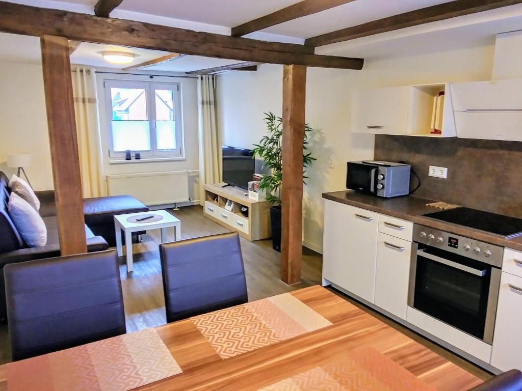 een keuken en een woonkamer met een tafel en een magnetron bij Ferienwohnung Schreiberstraße in Wernigerode