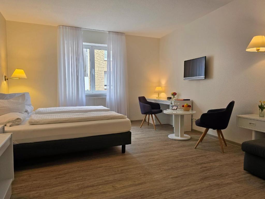 a hotel room with a bed and a desk at Hotel Samson in Beckum