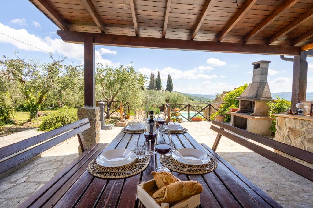 Monte Benichi的住宿－Little Escape-Casa con piscina e vista panoramica，天井上的木桌,上面有食物