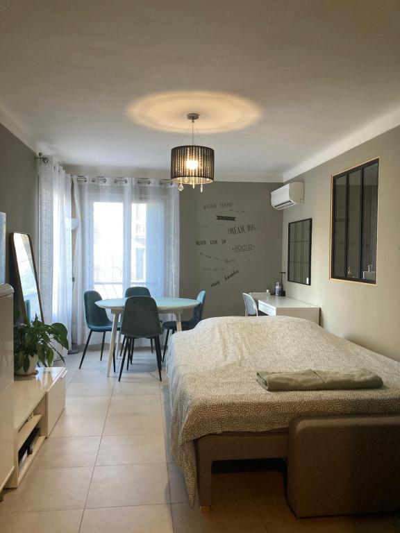 1 dormitorio con 1 cama, mesa y sillas en Nice west cosy flat balcony, near airport, train, beach, public transport, supermarket, comfortable and well equipped, en Niza