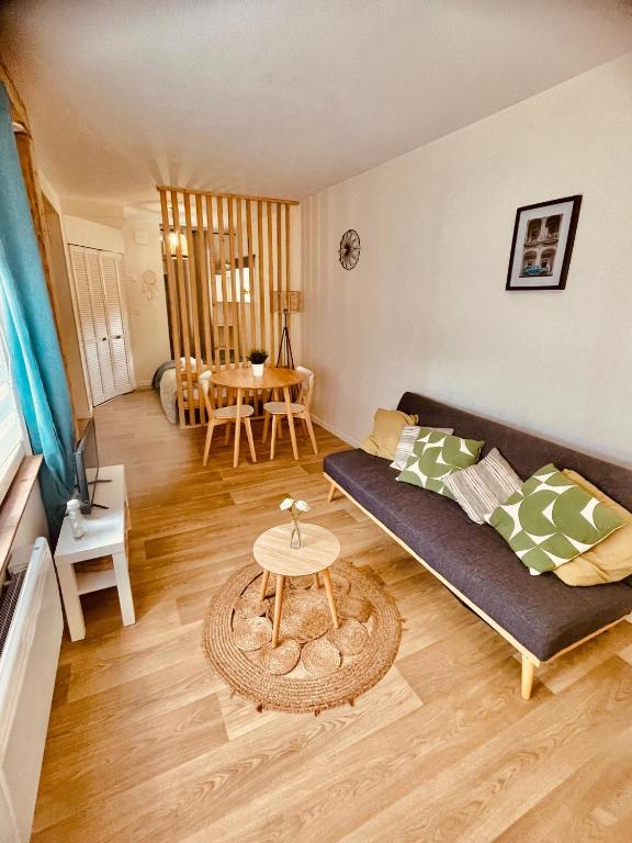 un salon avec un canapé et une table dans l'établissement Joli studio proche des remparts, à Boulogne-sur-Mer