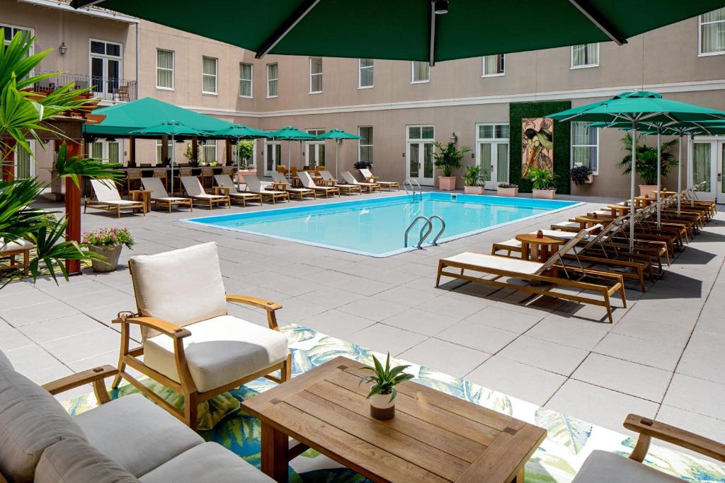 uma piscina com espreguiçadeiras e um hotel em Hyatt Centric French Quarter em Nova Orleans