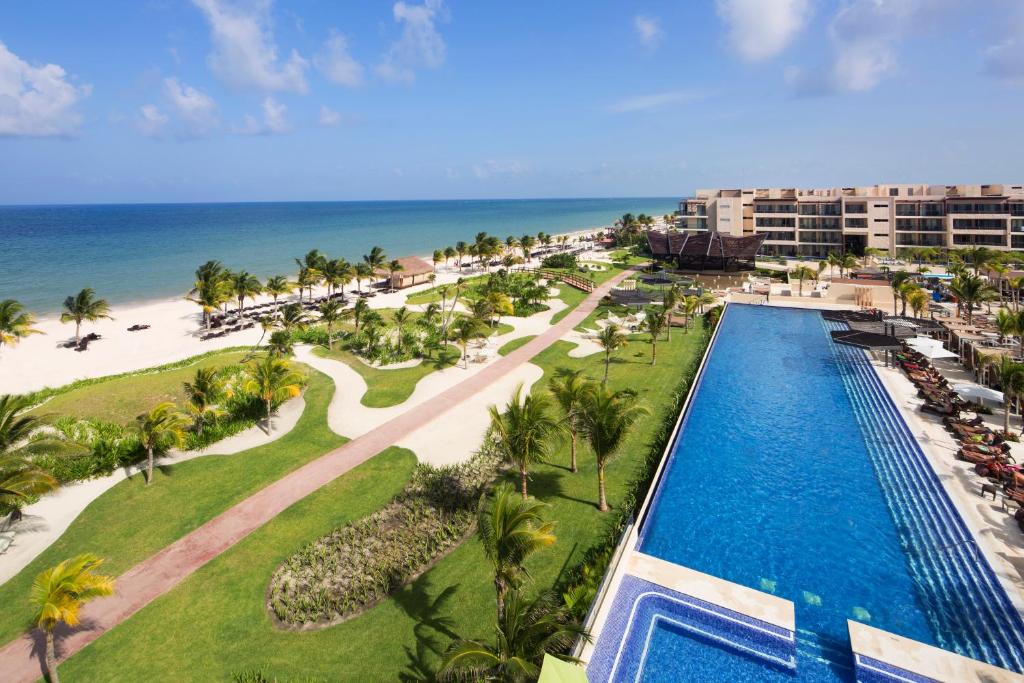 an aerial view of a resort with a swimming pool and the beach at Royalton Riviera Cancun, An Autograph Collection All-Inclusive Resort & Casino in Puerto Morelos