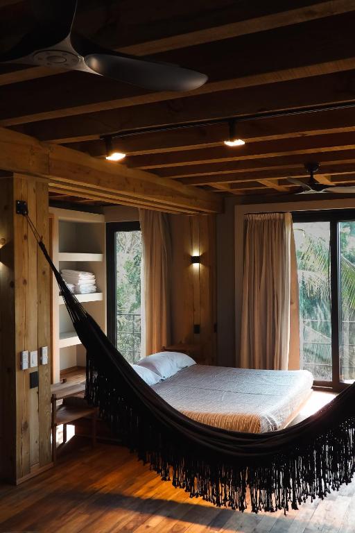 a hammock bed in a room with windows at Casa Matt & Marshall in Brisas de Zicatela