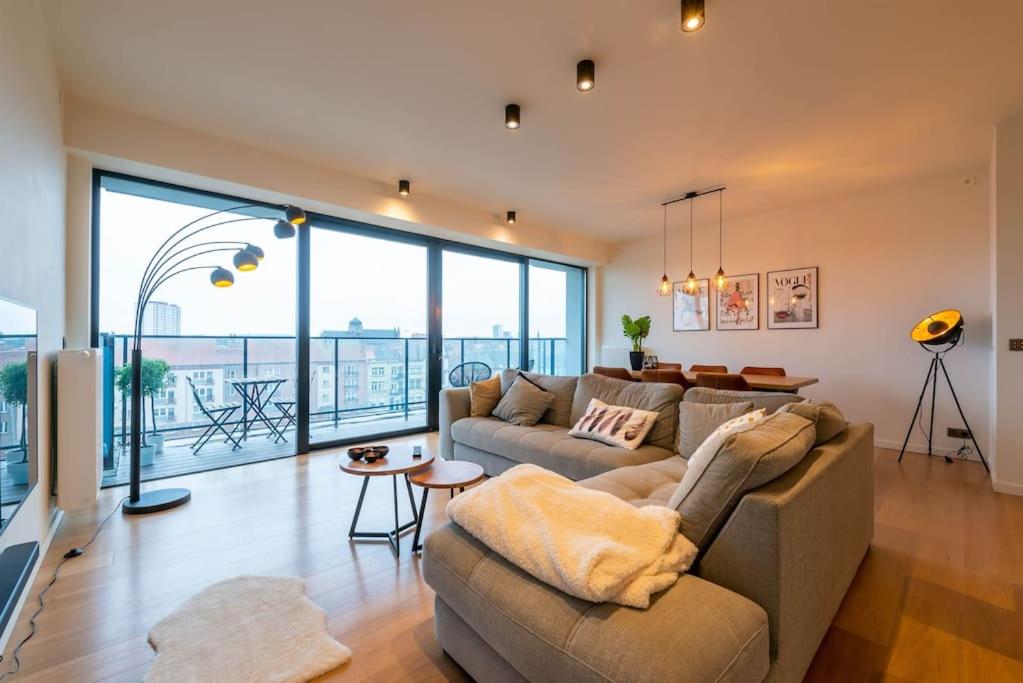 a living room with a couch and a large window at Casa Matti - Modern Apartment with Canal View and Terrace in Ghent