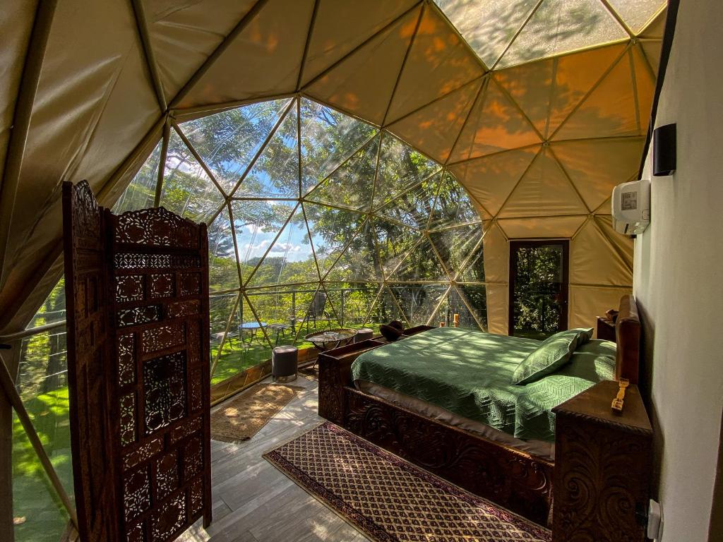 Way To Heaven Glamping في مونتيفيردي كوستاريكا: غرفة بسرير داخل خيمة