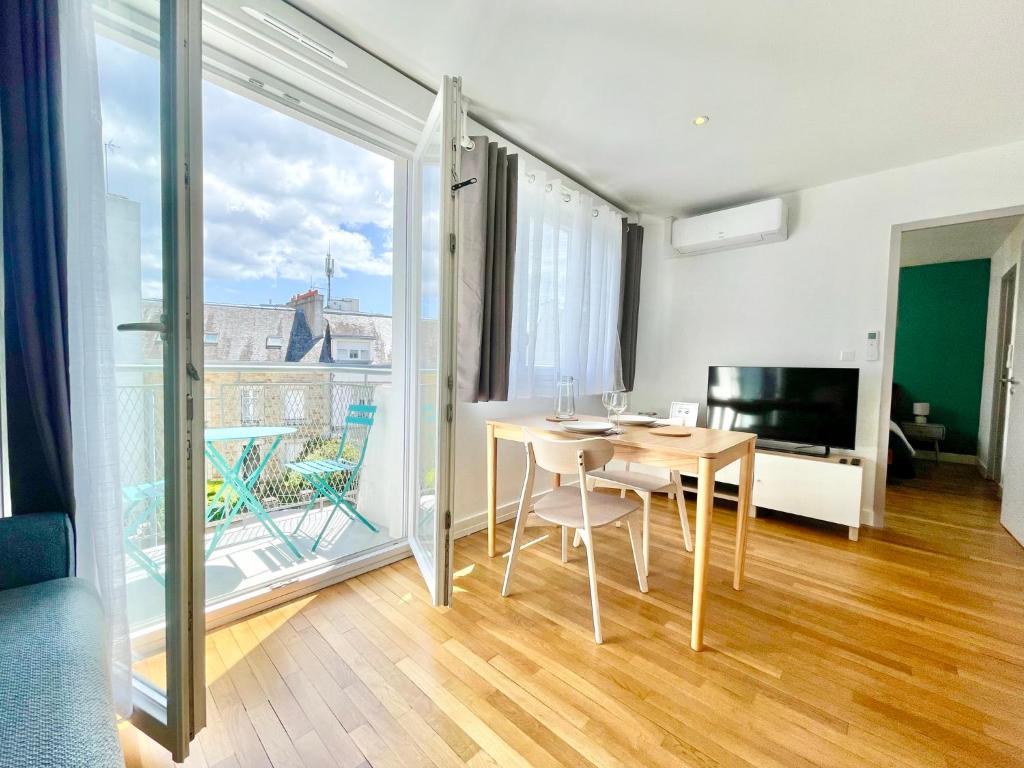 une salle à manger avec une table et un balcon dans l'établissement Les Alizés - Balcon - Climatisation, à Lorient