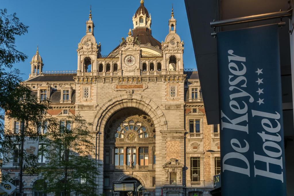 a large building with a clock on the front of it at De Keyser Hotel in Antwerp