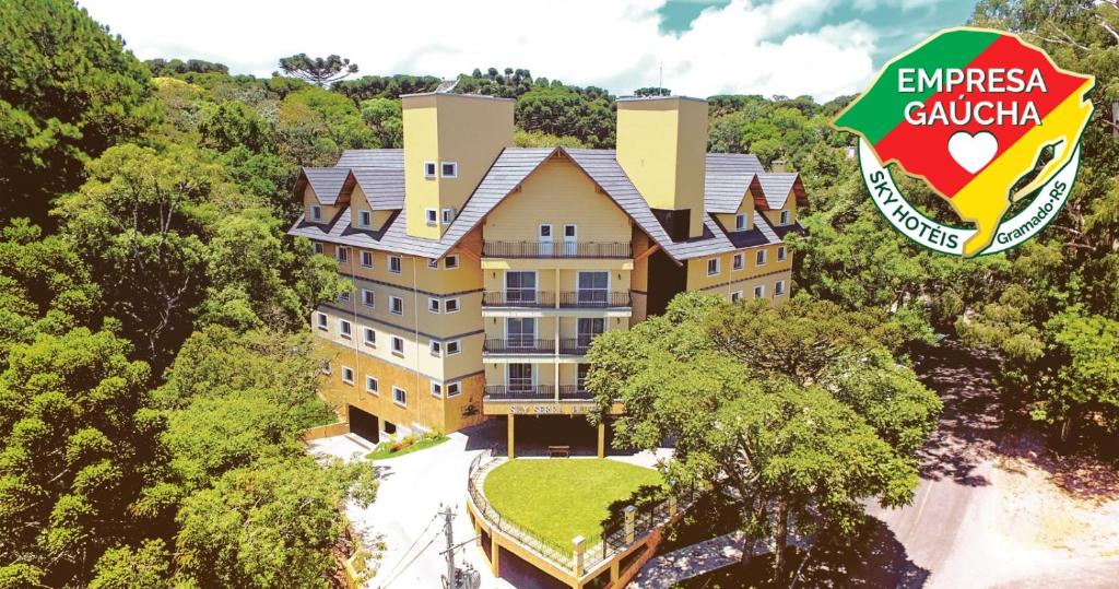 uma vista aérea de um edifício de apartamentos na floresta em Sky Serra Hotel em Gramado