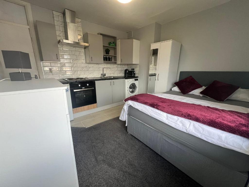a small bedroom with a bed and a kitchen at Premium Studio Apartment In Birmingham in Birmingham