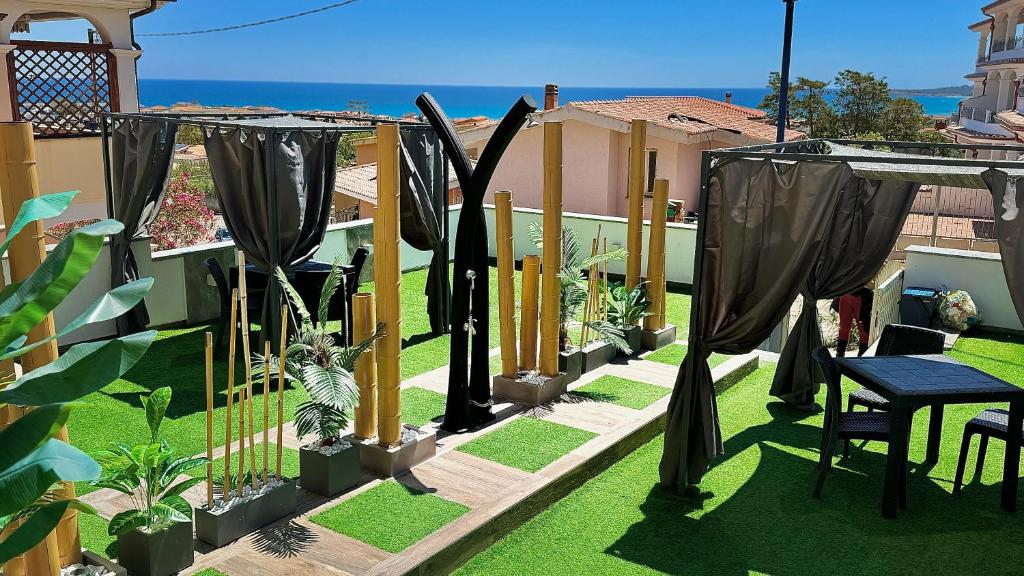 a backyard with a fence with plants and a table at Bellavista luxury apartments in La Caletta