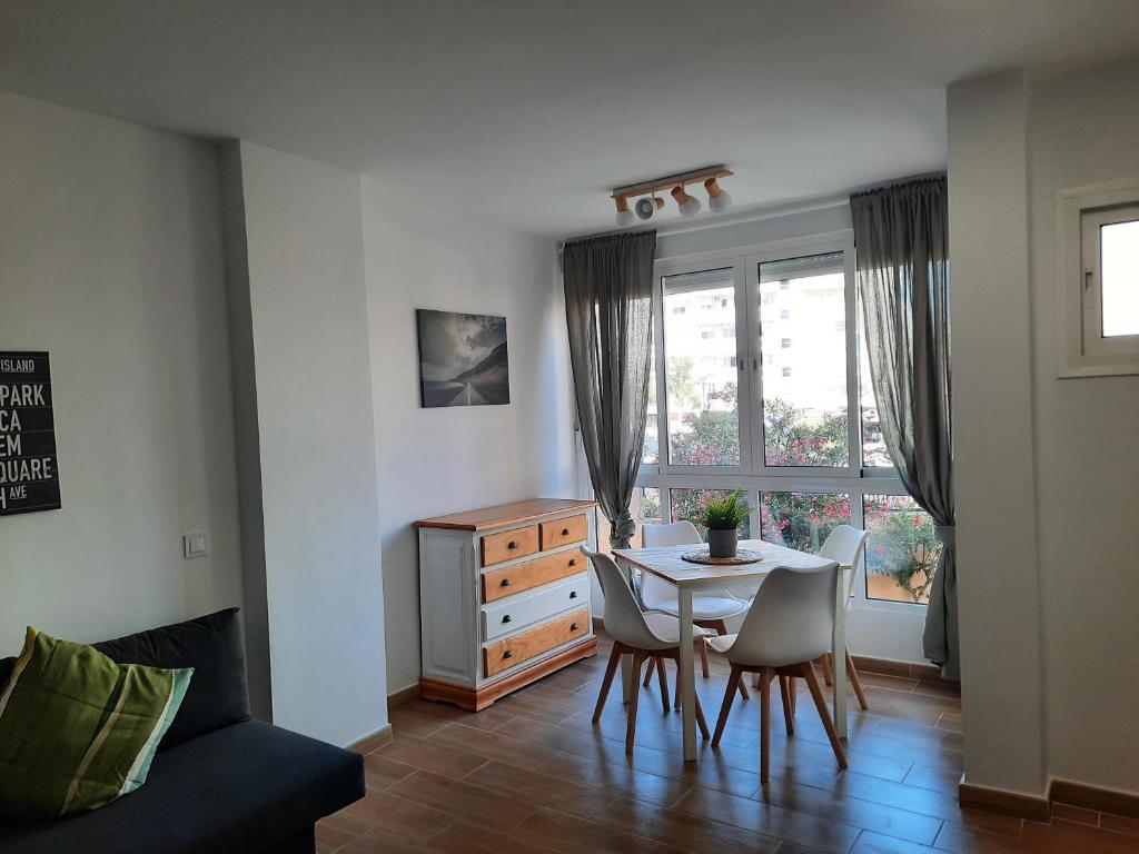 a dining room with a table and chairs and a window at Apartamento Veramar en Fuengirola in Fuengirola