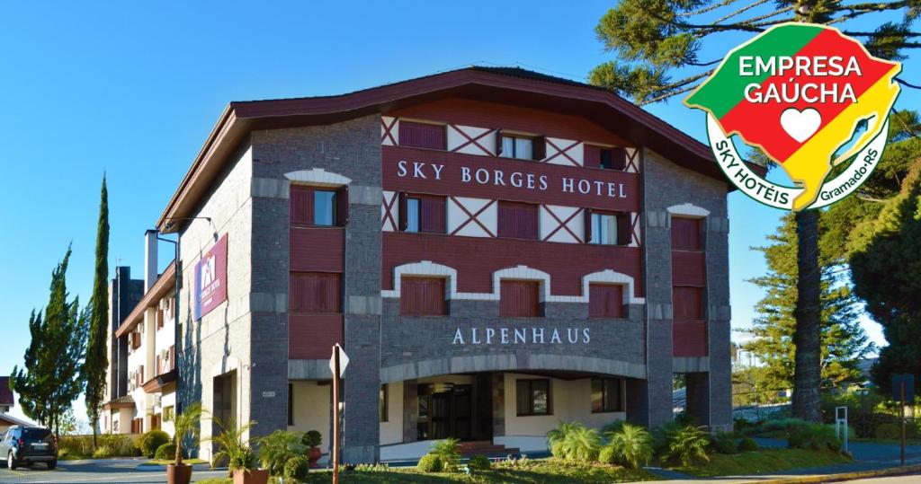 a building with a sign in front of it at Sky Borges Hotel Alpenhaus - Gramado in Gramado