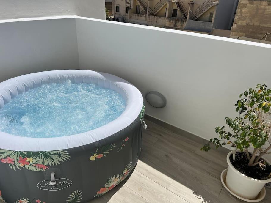 a hot tub in a room with a potted plant at Sea side view 2 bedroom apartment with terrace Beppe`s apartment in St Paul's Bay