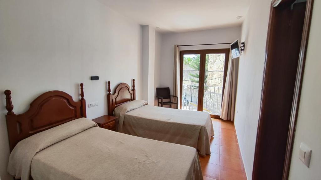 サアラ・デ・ロス・アトゥネスにあるHostal Jadrazaのベッド2台と窓が備わる客室です。
