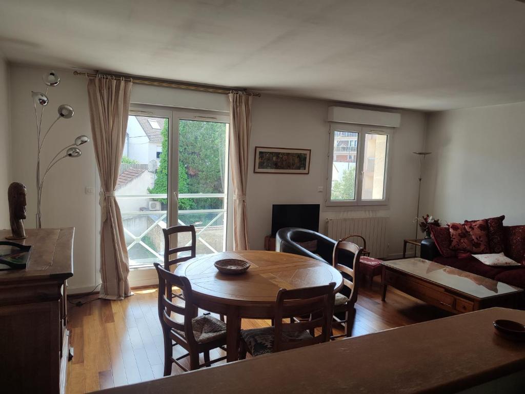 un salon avec une table et un canapé dans l'établissement Appartement Orsay Grand Paris, à Orsay