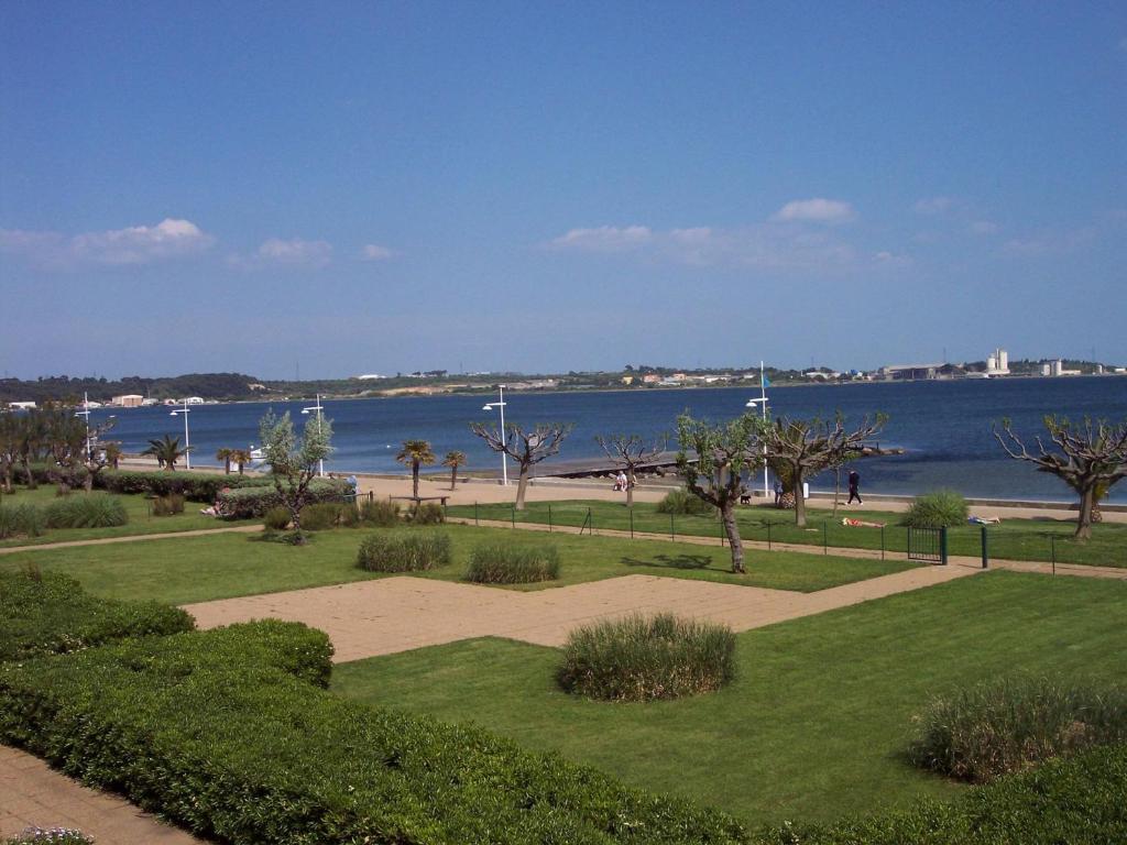 un parc avec vue sur l'eau et une plage dans l'établissement F1 confortable à Balaruc-les-Bains avec climatisation et animaux admis - FR-1-503-28, à Balaruc-les-Bains