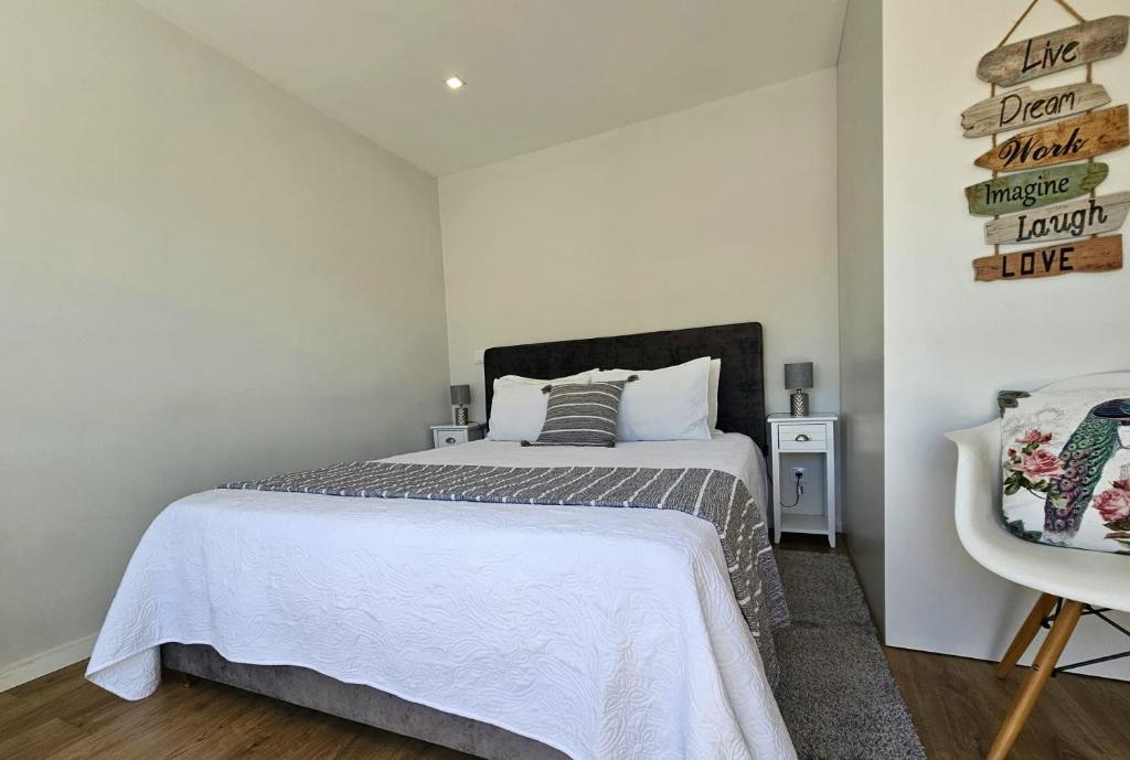 1 dormitorio con 1 cama y un cartel en la pared en Fascinante Orbita Apartments, en Vila Nova de Famalicão