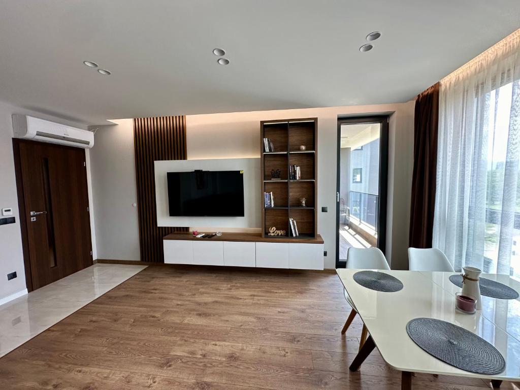 a living room with a table and a television at Apartment G17 in Pernik