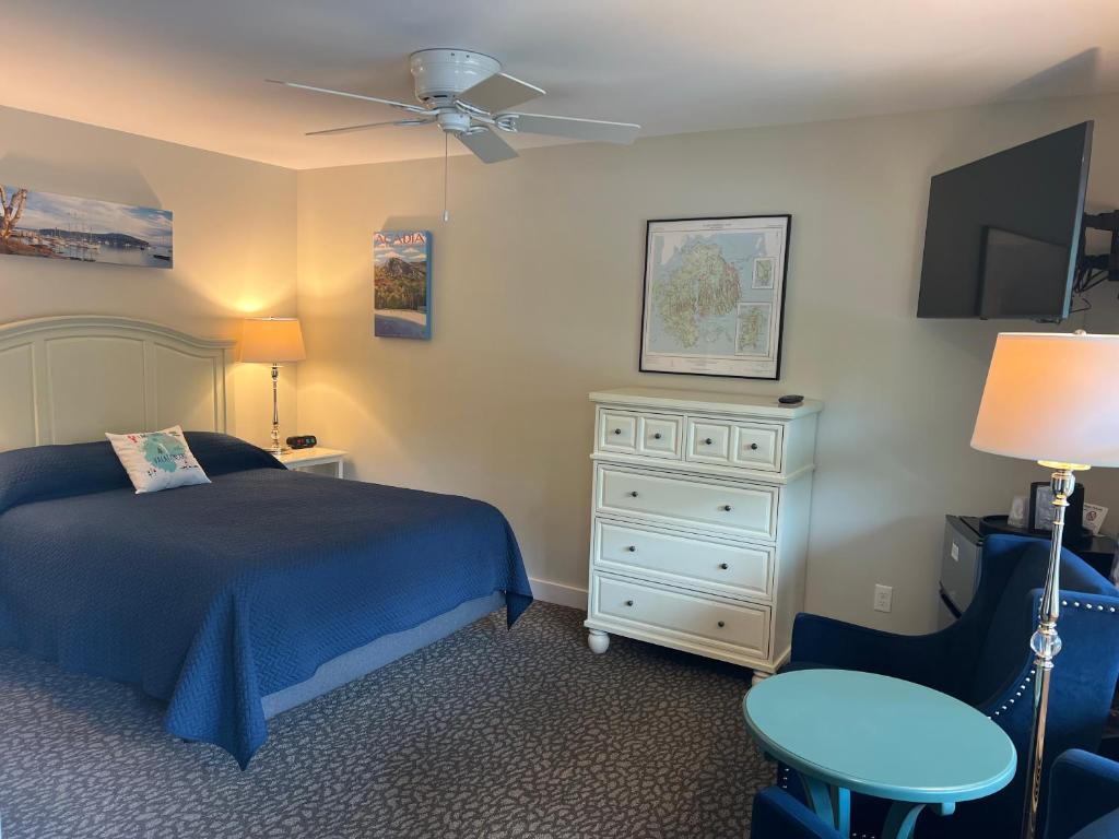ein Schlafzimmer mit einem Bett, einer Kommode und einem TV in der Unterkunft Island Place in Bar Harbor