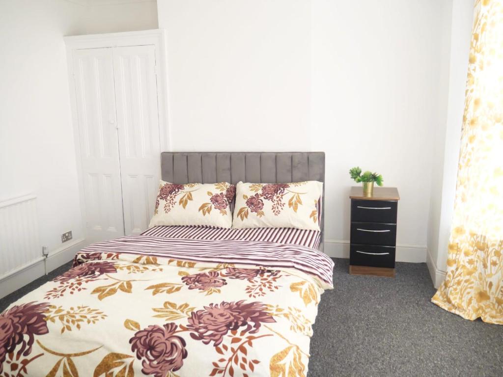 um quarto com uma cama com um cobertor e uma cómoda em Contractors Accommodation in Gillingham - Ideal for long and short stay em Gillingham