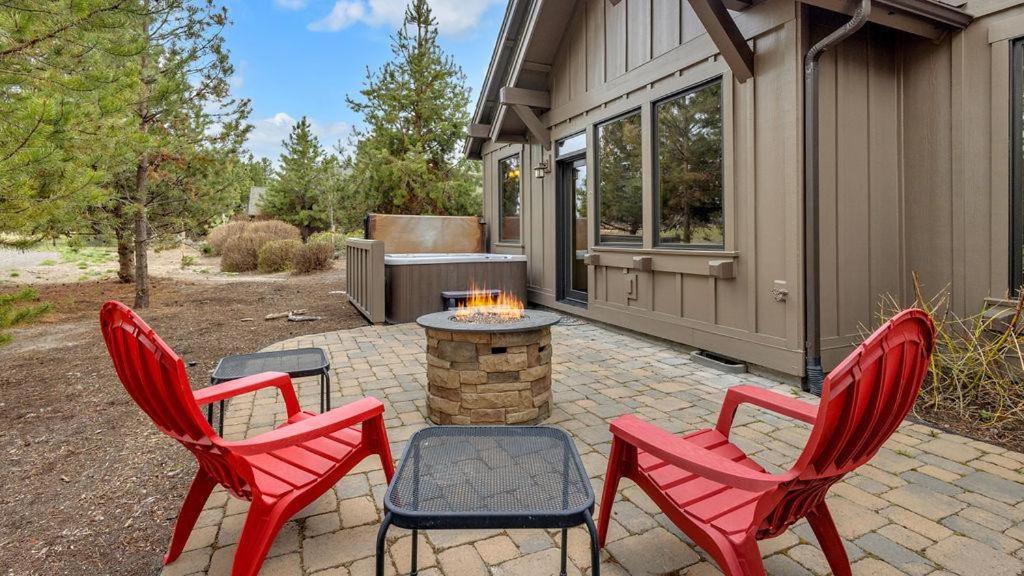 un patio con 3 sillas rojas y una hoguera en Caldera Cabin 6, en Sunriver