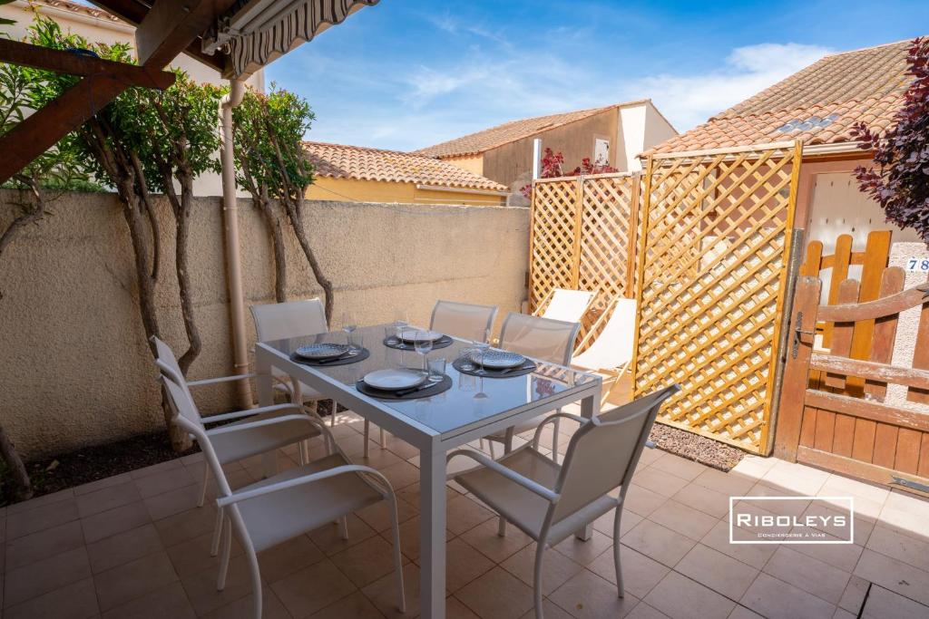 une table et des chaises assises sur une terrasse dans l'établissement Maison climatisée avec WIFI à 300m de la mer, à Vias