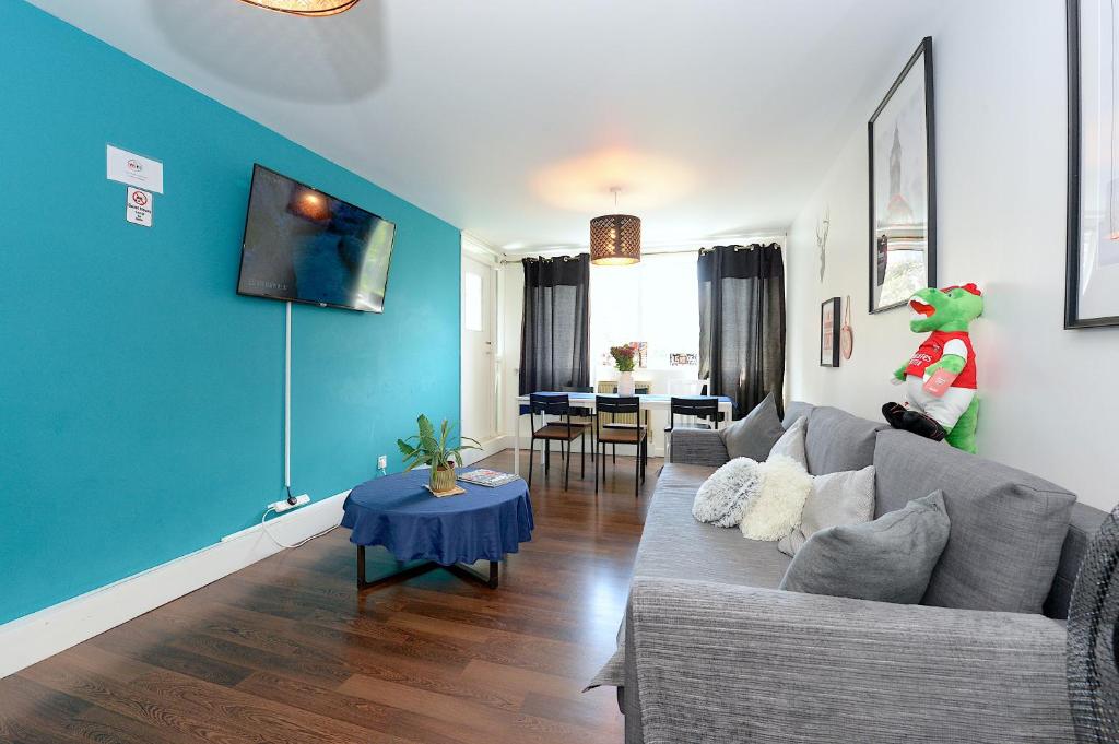sala de estar con sofá gris y pared azul en 3 BEDROOM FLAT IN CENTRAL LONDON - REGENTS PARK / BAKER ST, en Londres