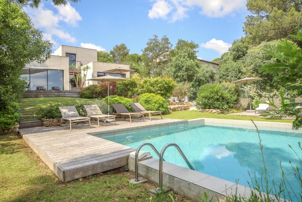 un patio trasero con piscina y una casa en Villa CONTEMPORAINE Piscine Montpellier en Montpellier