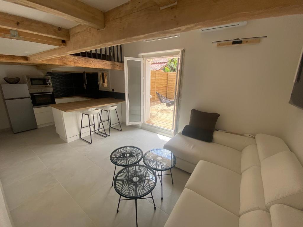 Il comprend un salon avec un canapé et des tables ainsi qu'une cuisine. dans l'établissement Appartement rénove à Saint Aygulf, à Fréjus