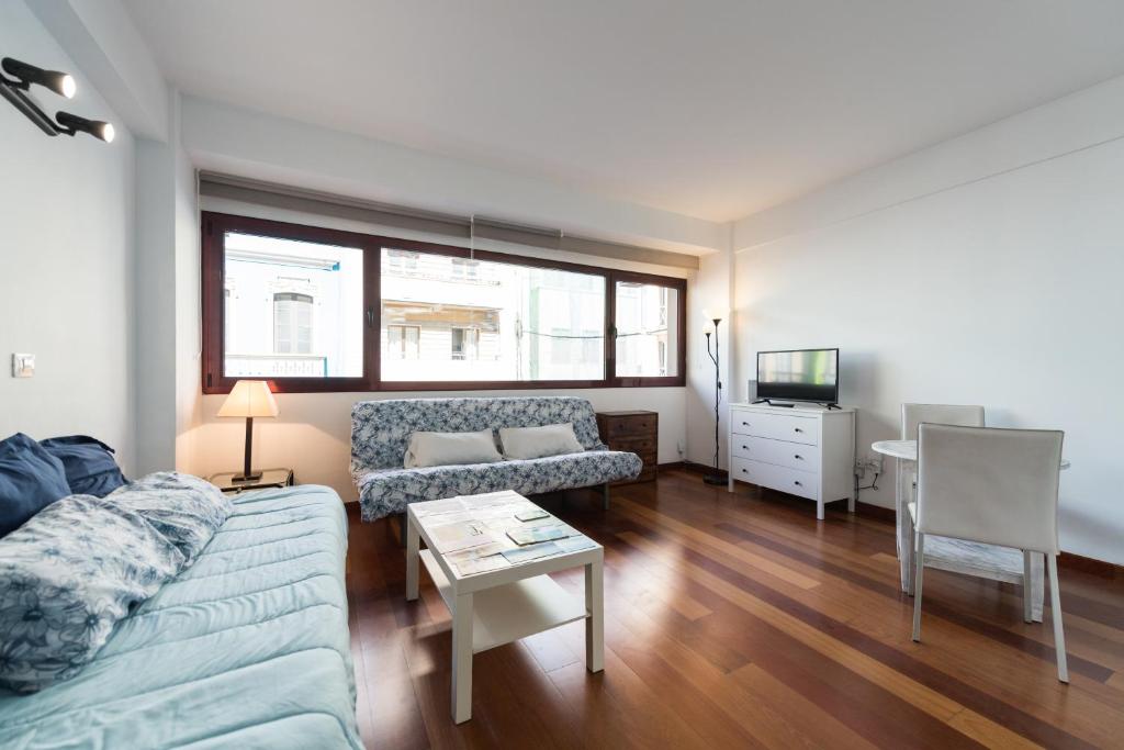 un soggiorno con divano e tavolo di Loft moderno y cómodo a un minuto de Las Canteras a Las Palmas de Gran Canaria