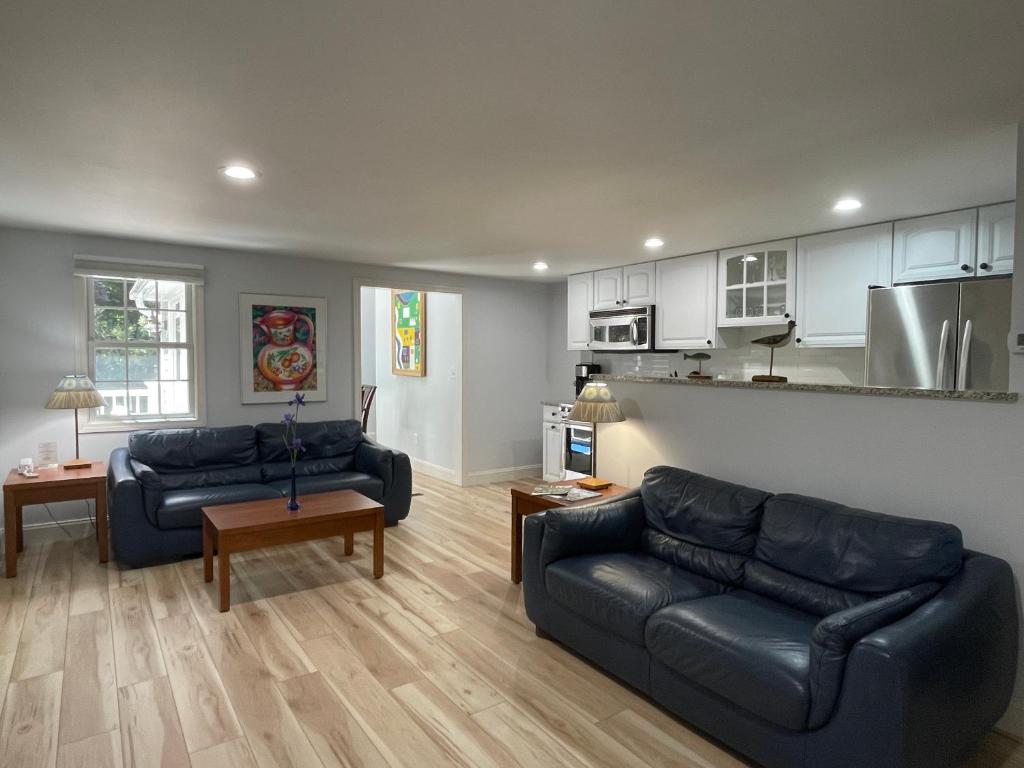 a living room with two couches and a kitchen at Pleasant Bay Village Resort in Chatham