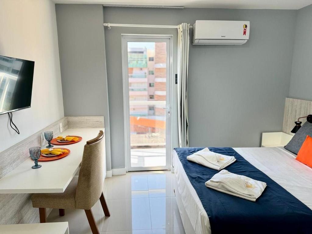une chambre avec un lit et une table et un lit et une salle à manger dans l'établissement Flat 426 comodidade na Passagem em Cabo Frio, à Cabo Frio